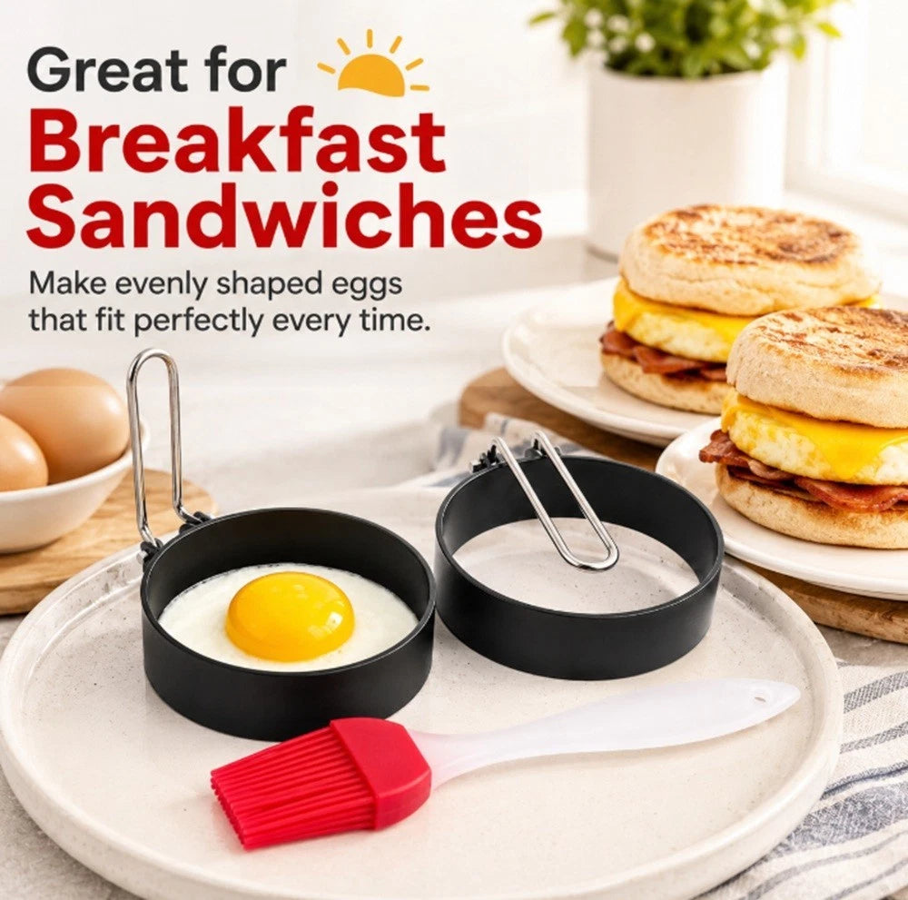 Egg cooking mold rings with eggs and a spatula on a plate, with breakfast sandwiches in the background.