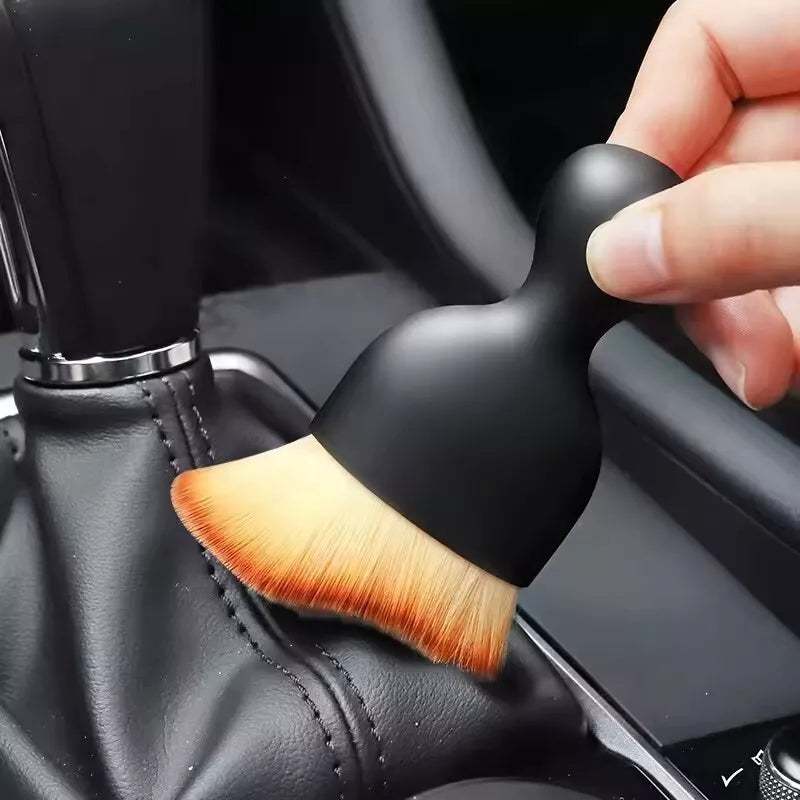 Car interior auto detail cleaning brush being used on a car seat.