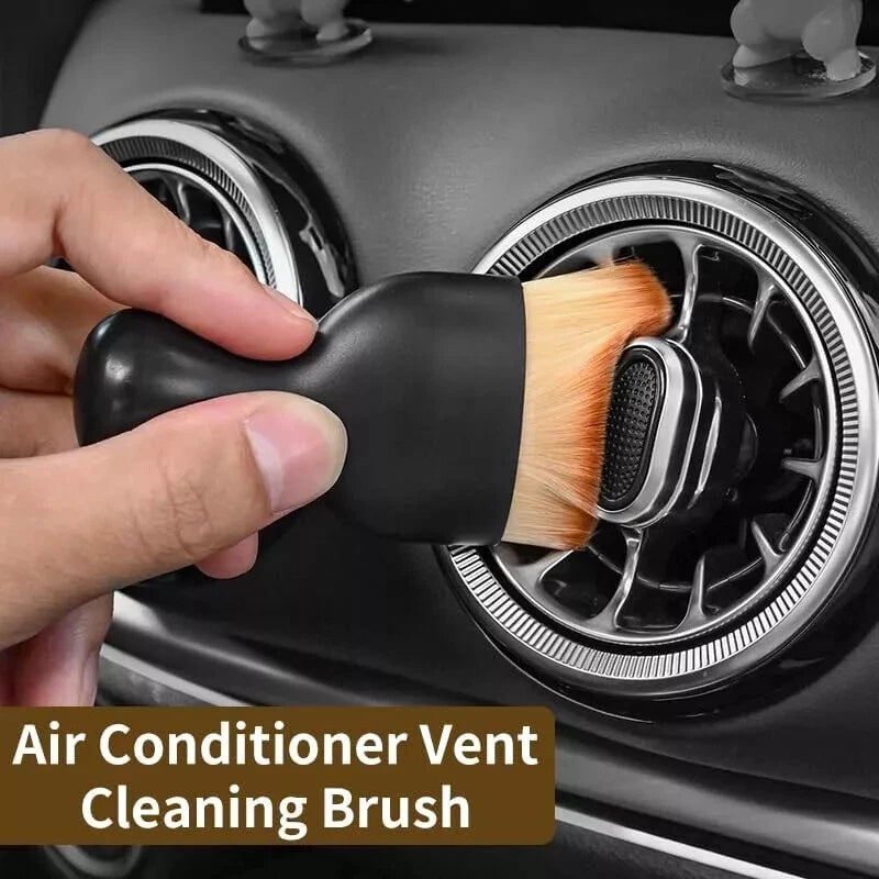 auto detail brush being used on cleaning car's air conditioner vent.