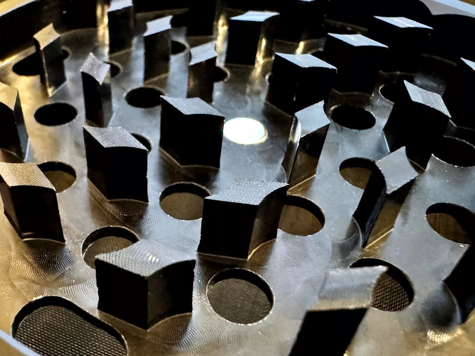 Close-up of a CNC machined sharp grinder teeth in black Crush labs aluminum grinder