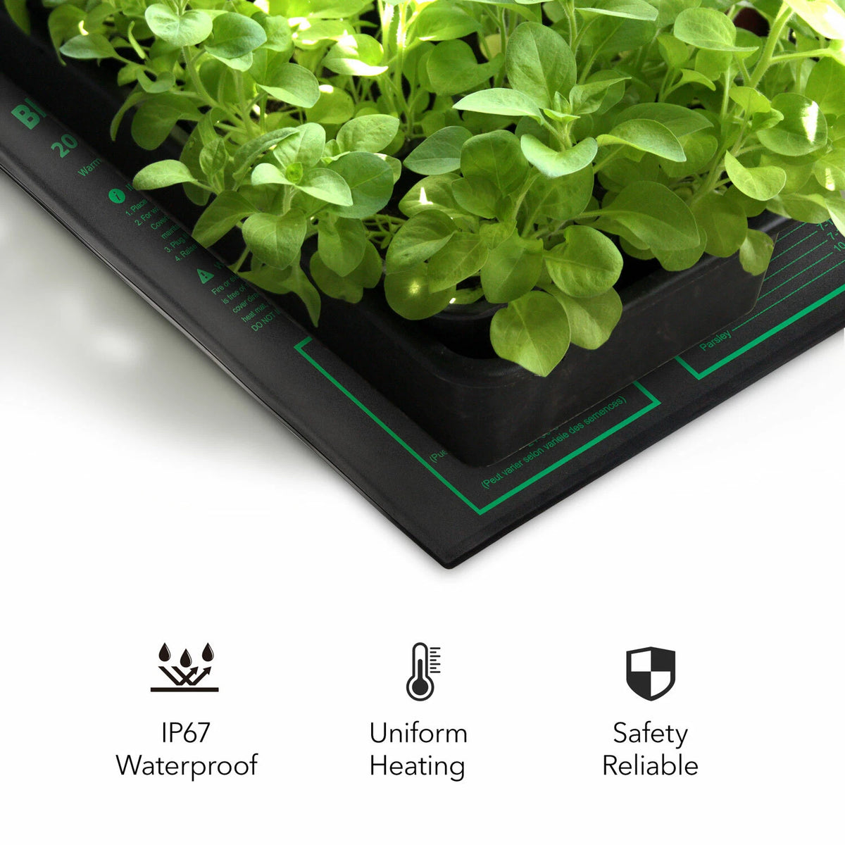 Black seed starting heat mat under indoor herb garden tray filled with green leafy plants, shown on a white background with feature icons and text below: IP67 waterproof, uniform heating, and safety reliable.
