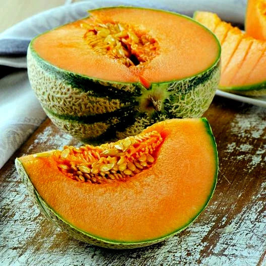 Sliced Charentais cantaloupe melon on wood table. 
