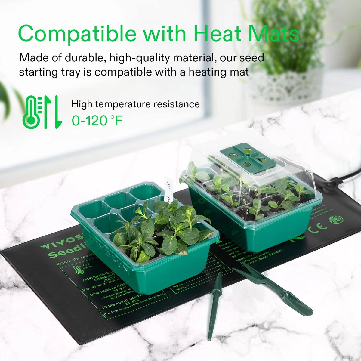 Seed starting trays with plants on a heating mat, compatible with heat mats.