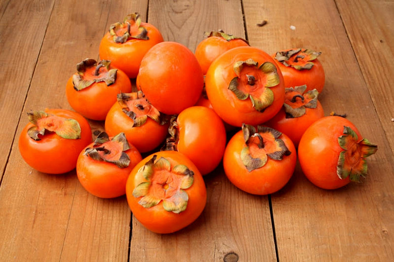 Japanese persimmon fruits on a wooden surface