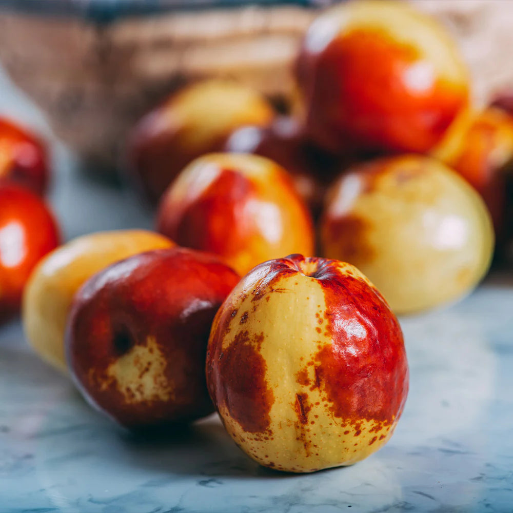 Close-up of jujube fruits on a textured surface with a blurred background