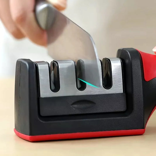 A hand using a 3-stage professional kitchen knife blade sharpener tool with a black and red handle.