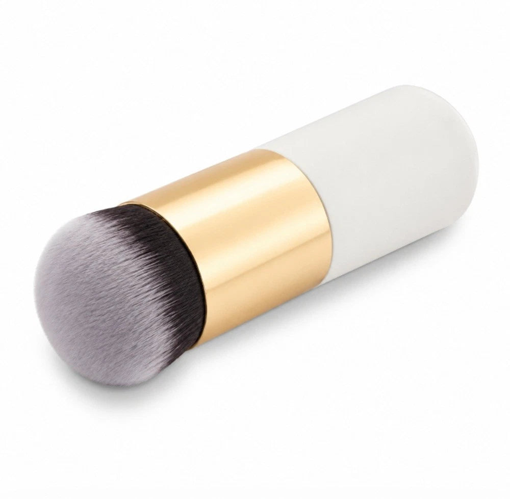 A kabuki makeup brush with a white handle, a shiny gold metallic ferrule, and soft gray bristles that fade to black at the tip, shown on a clean white background.
