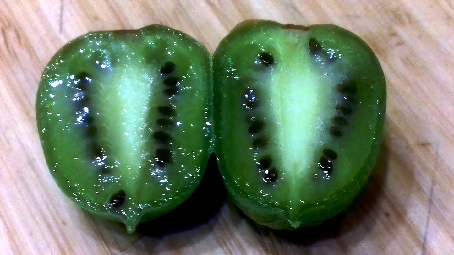 Two halves of a green Issai skinless kiwi fruit on a wooden surface