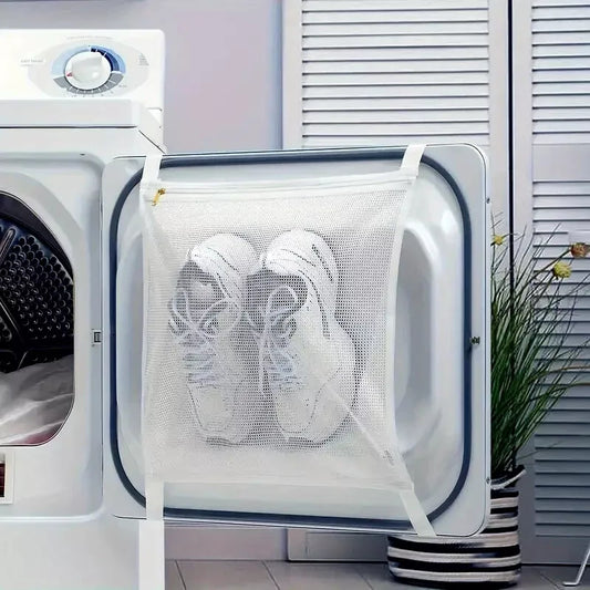 Large laundry mesh sneaker wash bag holding two tennis shoes strapped to open dryer door