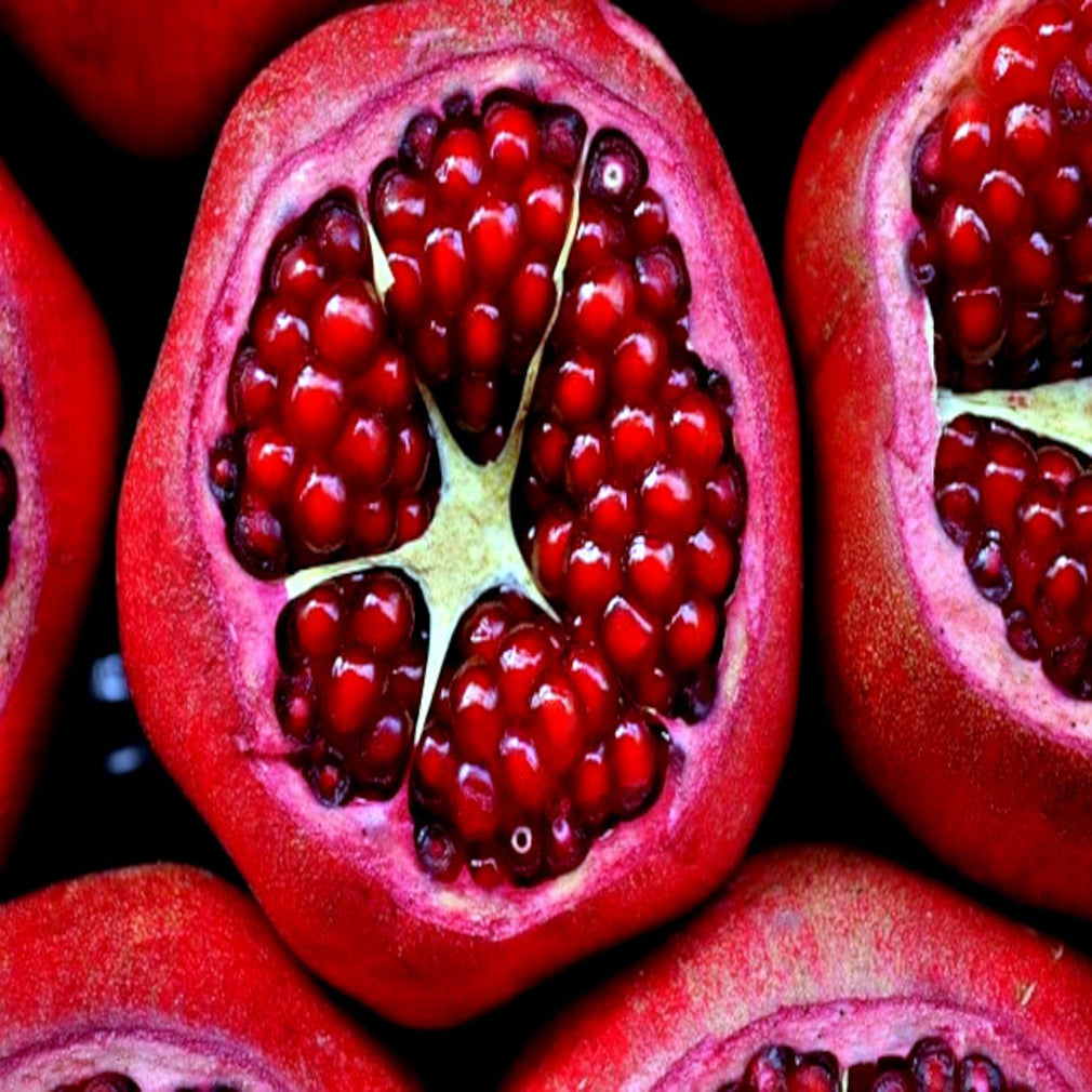 Close-up of a halved pomegranate with juicy red seeds.
