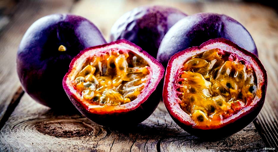Purple passionfruit cut in half on wooden table. 