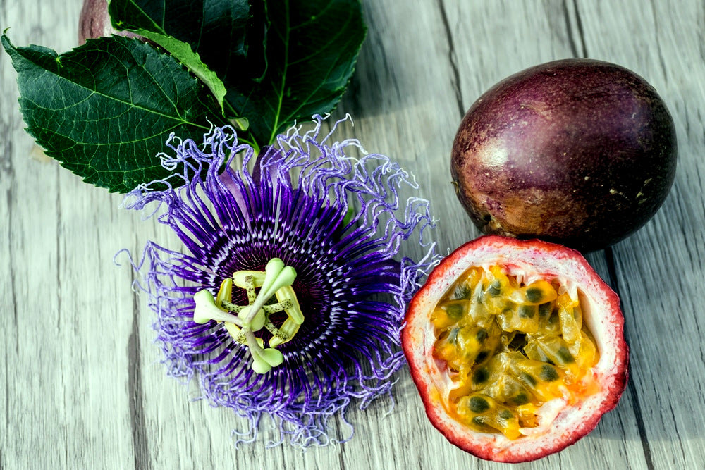 Purple passionfruit flower with passionfruit on wooden table.