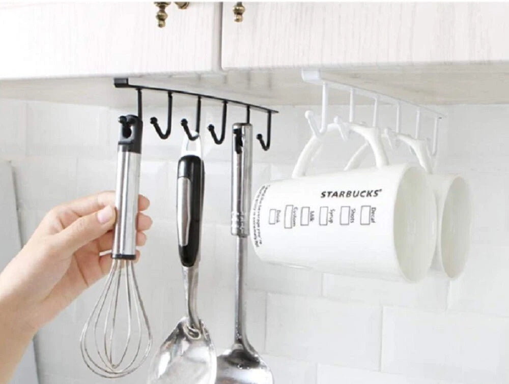 Under-the-shelf cabinet organizer with hanging utensils and a Starbucks mug.