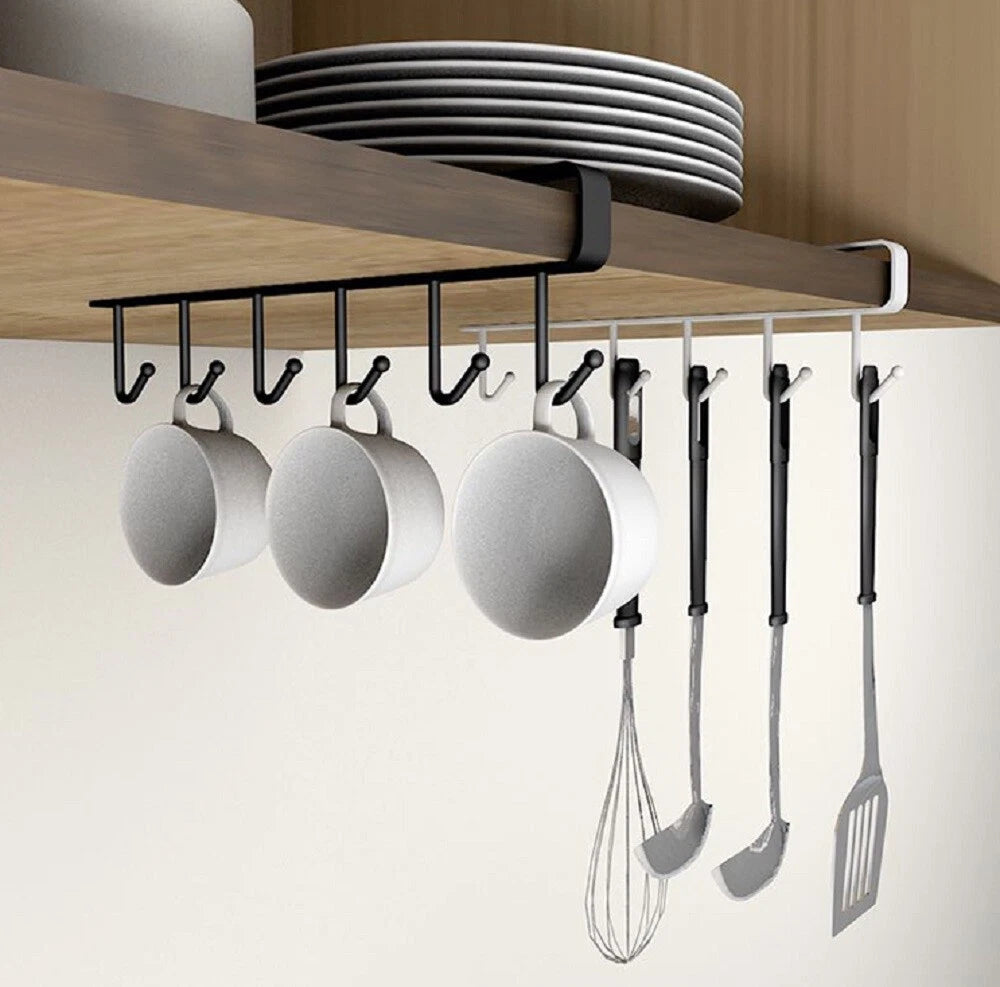 Kitchen utensil under-the-shelf holder with hanging pots, pans, and utensils under a wooden cabinet.