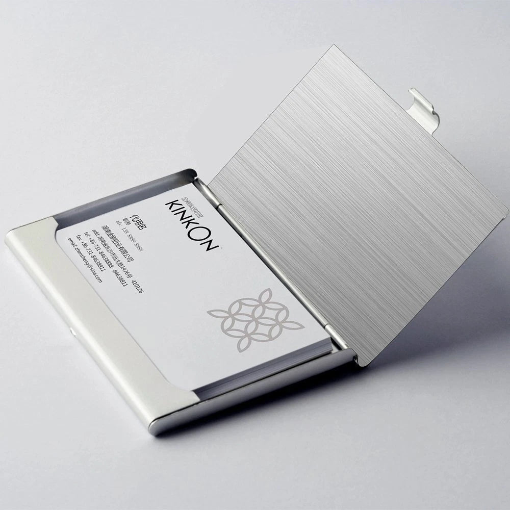 Metallic finish stainless steel business card holder with KINNOK branding on a light gray background
