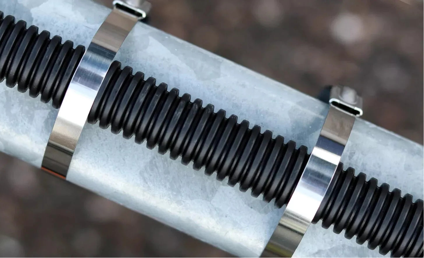 close up of .18" wide stainless steel zip tie holding conduit to a pipe