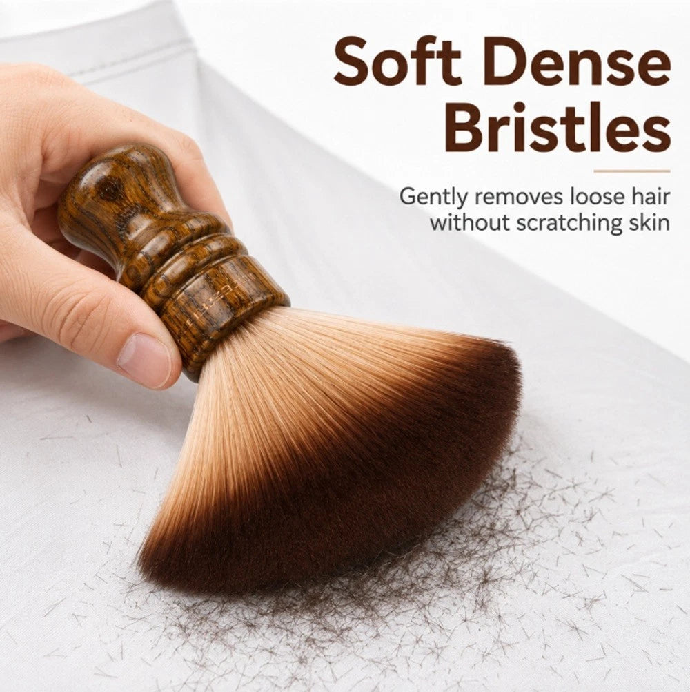 A hand holds a barber neck duster brush with a glossy brown wooden handle and soft dense brown-to-cream bristles, shown on a white surface with loose hair beneath the brush. Text reads 'Soft Dense Bristles' and 'Gently removes loose hair without scratching skin.